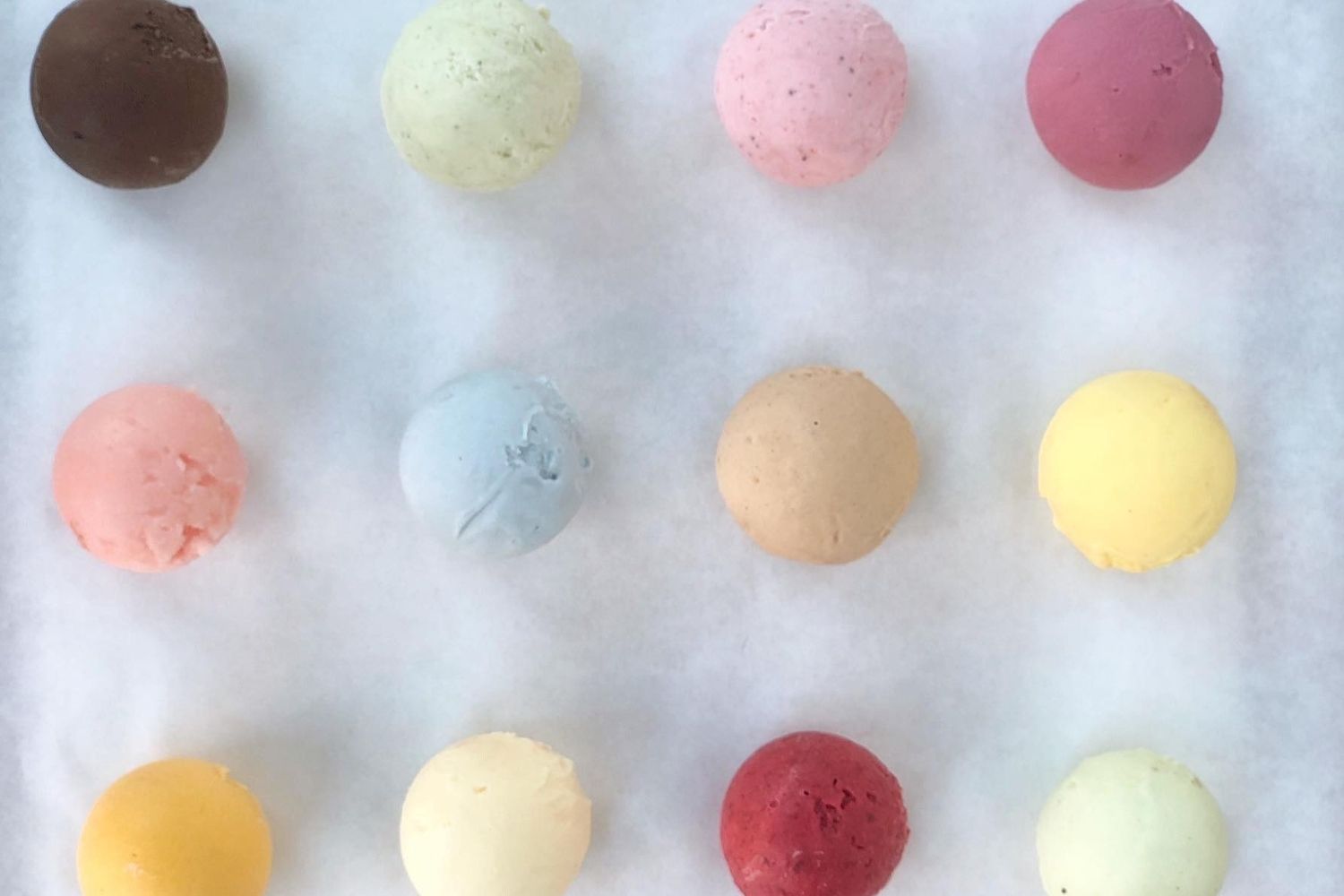 Fifteen naturally coloured gelato and sorbet scoops arranged in a rainbow grid