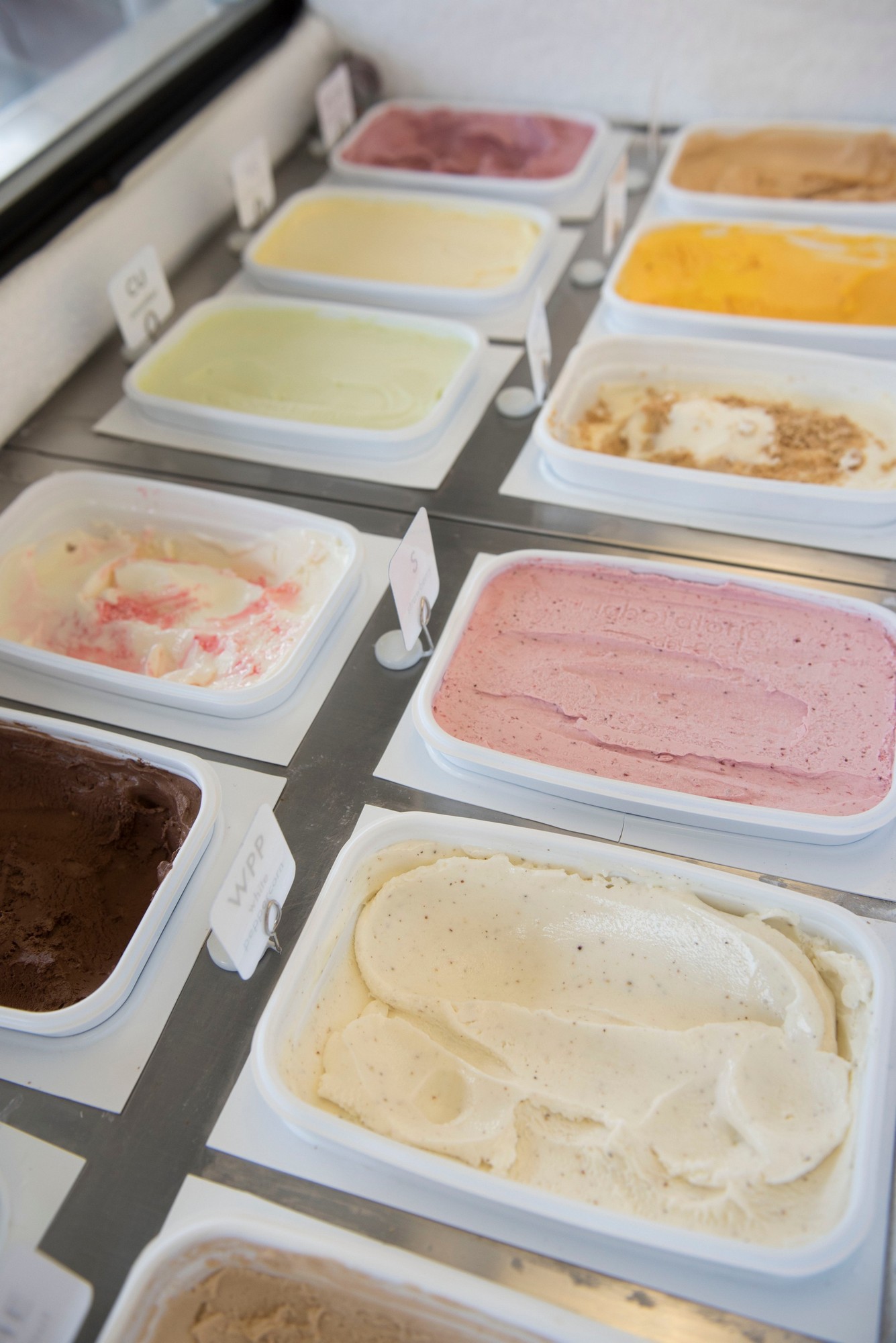 Colorful display of vegan sorbet flavors in various containers